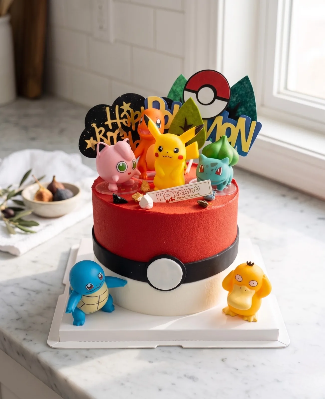 Red Pokéball Pokémon birthday cake with Pikachu, Bulbasaur, Jigglypuff, Squirtle and Psyduck figurines